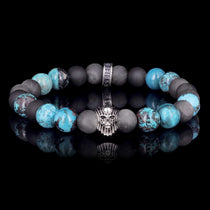 Bracelet Cyané Olivier Ledroit x Flibustier Paris : perles de shattuckite bleue et d'obsidienne argentée mate de 8 mm autour d'un visage sculpté en argent 925